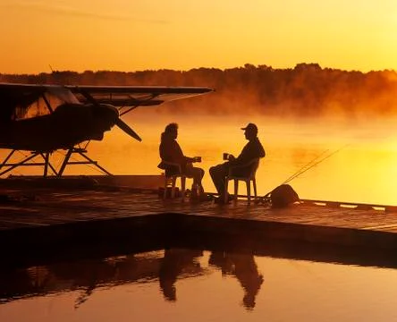 A couple relaxes on a float plane dock, Manitoba, Canada Stock Photos