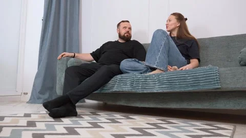 Couple relaxing and talking on sofa in living room Stock Footage 317441630