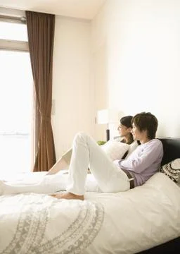 Couple relaxing on bed Stock Photos