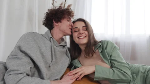 A couple is relaxing on a bed, sharing an intimate moment filled with love in a Stock Footage 276390704