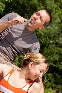 Couple relaxing with e-cigarette Stock Photos