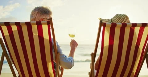 Couple Relaxing Enjoying the Sunset on the Beach Stock Footage 74287623