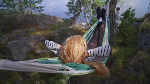 Couple relaxing in hammock by lake, authentic outdoor moment in wild natur Stock-Footage 331846345