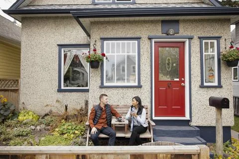 Couple relaxing with hot drink at front porch Fotos Stock