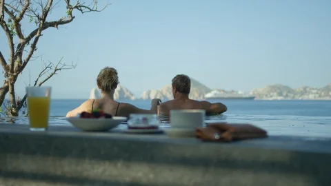 Couple relaxing in infinity pool Stock Footage 106323877