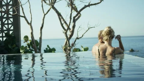 Couple relaxing in infinity pool Stock Footage 106330772