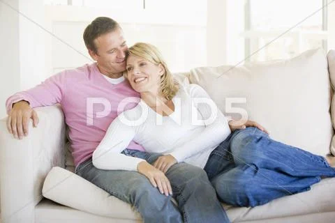 Couple relaxing in living room and smiling Stock Photos