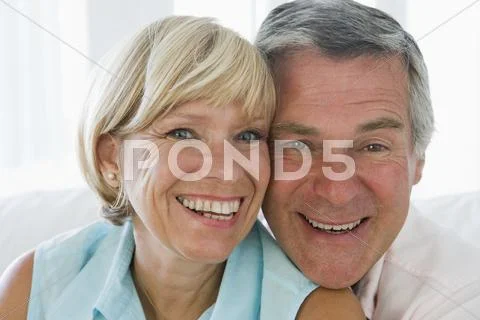 Couple relaxing in living room smiling Stock-Fotos