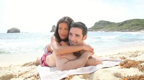 Couple relaxing on a sandy beach Stock Footage 14827570