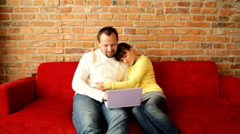 Couple relaxing in sofa with laptop computer  Stock Footage 1214469