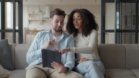 Couple Relaxing on Sofa, Using Tablet and Credit Card for Online Shopping Stock Footage 299286149