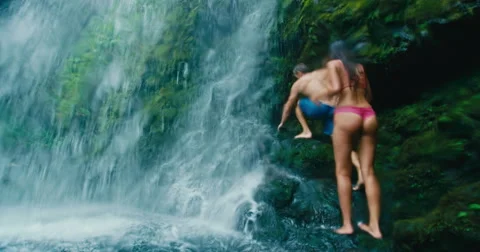 Couple Relaxing Under Waterfall Stock Footage 64938624
