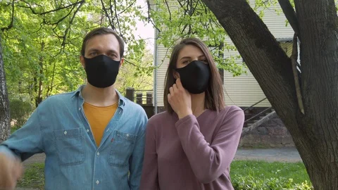 Couple removing protective face masks from each other. Celebrates end of quarant Stock Footage 130085656