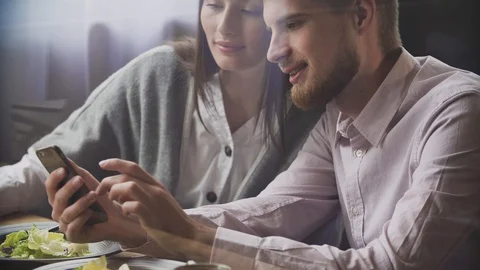 Couple at restaurant looking at his smart phone Stock Footage 111246751