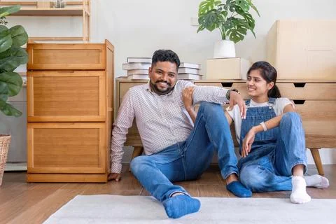 A couple resting after picking up boxes for moving house. Drinking water and Foto stock