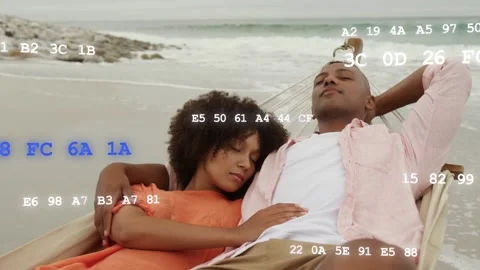 Couple resting in hammock on shore as tech code starting floating across frame Stock Footage 333911167