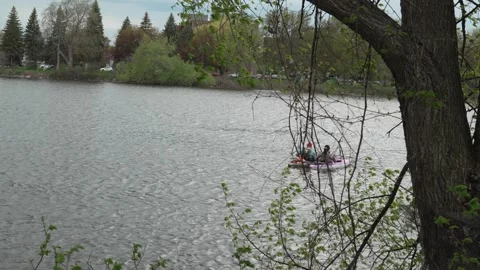 Couple Resting in Separate Canoes Drifting Together on Lake Stock Footage 335230670