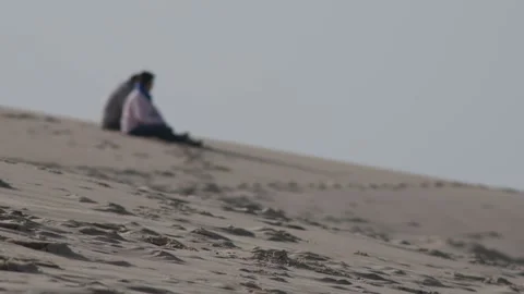 Couple resting on the top of the Dune du Pilat Stock Footage 170946775