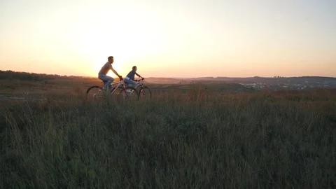 Couple is riding a bicycle at sunset Stock Footage 80838605