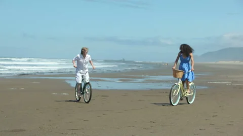Couple riding bicycles on beach Stock Footage 62279983