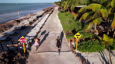 Couple Riding bikes through beautiful coastline, island Holbox, Mexico Stock Footage 233428503
