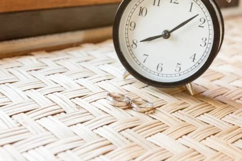 Couple ring on weave table with clock Stock Photos