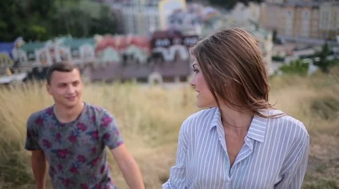 Couple rises up the hill on the background of the city Stock Footage 68355127