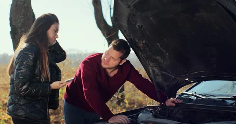 Couple on the road having problem with a car. Broken down car on the road Stock Footage 165146449
