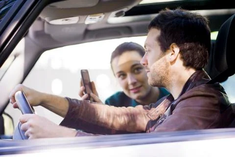 Couple on road trip using smartphone app to navigate Stock Photos