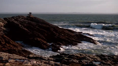 Couple on the rock in wild beach. Rough ocean. Super slow motion 4k Vídeos de archivo 335043827