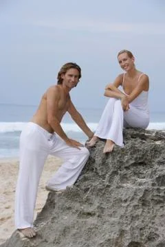 Couple on rocks on seashore Stock Photos