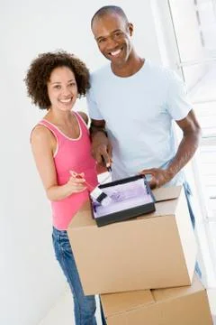 Couple with roller and paint in new home smiling Stock Photos