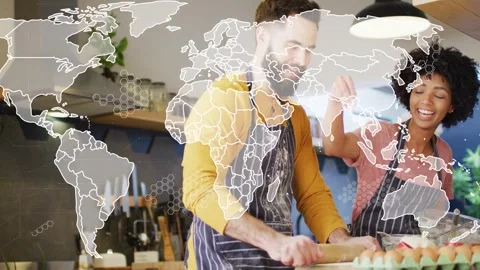 Couple rolling dough and cracking eggs while world map overlay fading in, Stock Footage 333004587