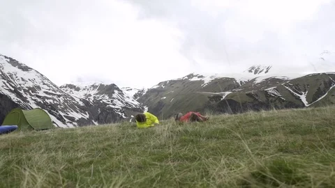 Couple rolling over grass at campsite 스톡 동영상 72508064