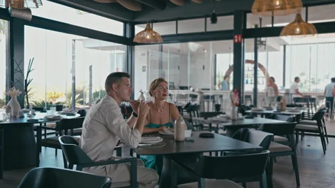 Couple on romantic date, sit at table in an elegant restaurant, talk and la.. Vídeo Stock 331874889