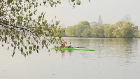 Couple rowing on the tranquil river against ancient buildings, slow motion video Vídeo Stock 143140226