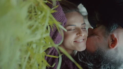 Couple rubbing their faces together while lying down on grass outdoors Stock Footage 275274908