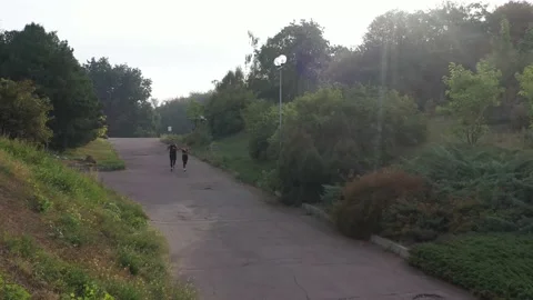 Couple run panoramic view. Drone view of two runner jogging in park Stock Footage 141056697