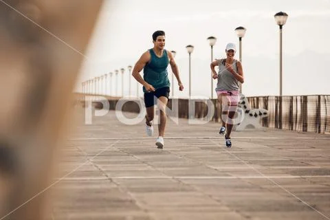 Couple of runners competing on promenade Stock Photos