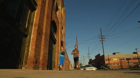 A couple running and working out together in urban environment, slow motion. Stockbeeldmateriaal 68537369