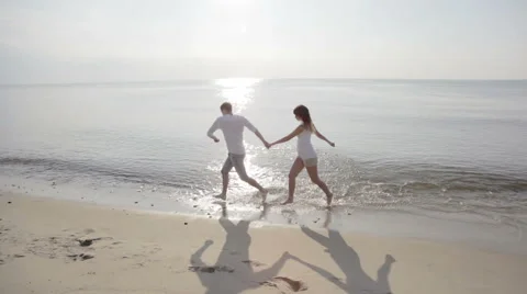 Couple running on a Beach Stock Footage 61879459