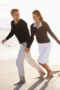 Couple running on the beach Stock Photos