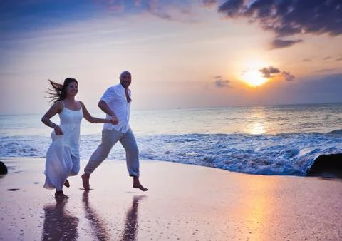 Couple running at the beach Stock Photos