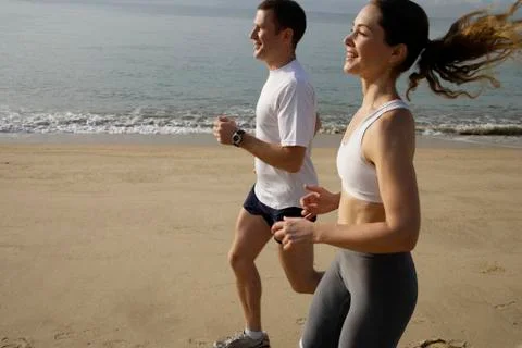 Couple running on beach Stock Photos