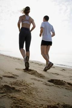 Couple running on beach Stock Photos