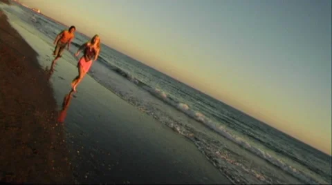 Couple running on beach at sunset and embracing Stock Footage 43689179
