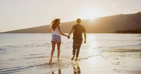 Couple running on the beach together Stock Footage 106514399