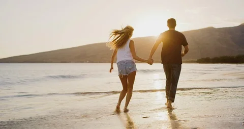 Couple running on the beach together Stock Footage 106514792