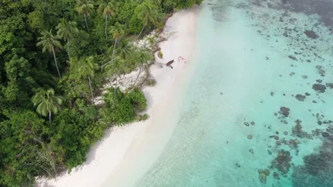 Couple Running Down White Sand Beach in Raja Ampat With Red Scarf Adventure Stock Footage 197059099