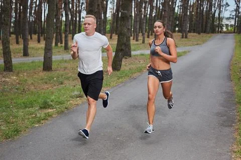Couple running in forest Stock Photos